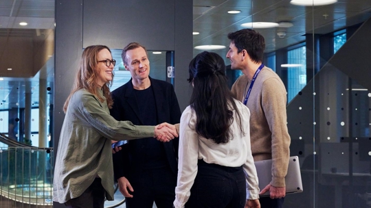 People meet and greet smiling shaking hands